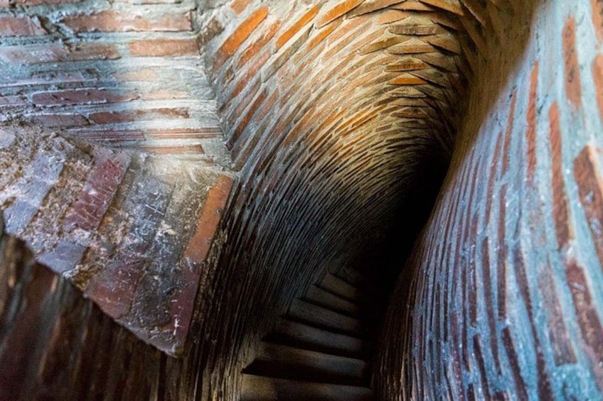 A close-up of a brick archway with a spiral staircase. 3