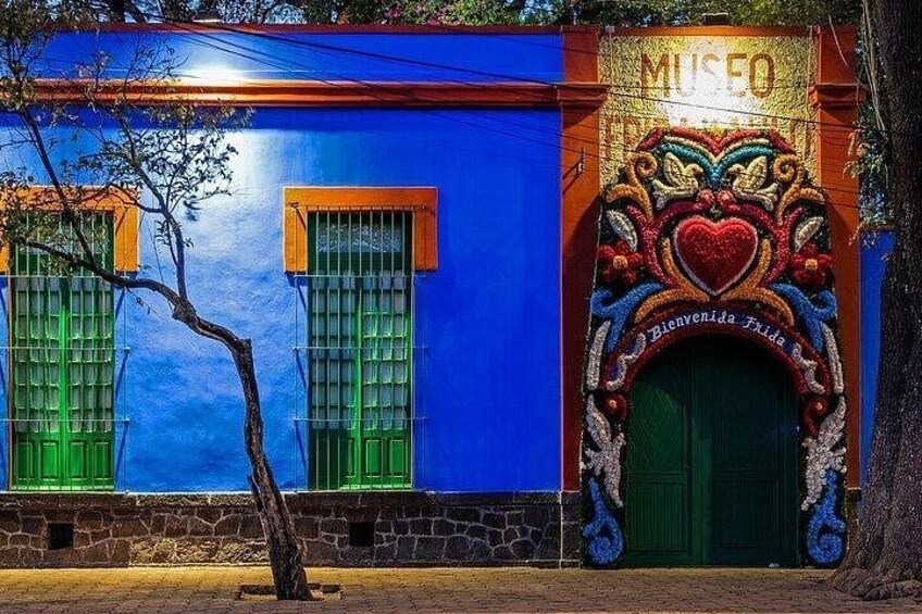 A building with a blue facade, green windows, and a decorative entrance with a heart motif. 2