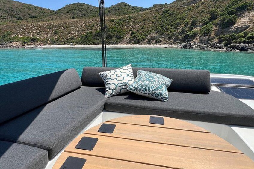 A boat's deck with a cushioned seating area and a wooden table. 5