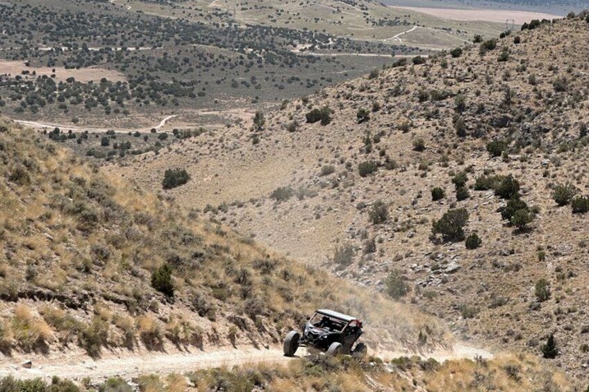 Un vehículo recorre un terreno montañoso y accidentado, con poca vegetación. 4