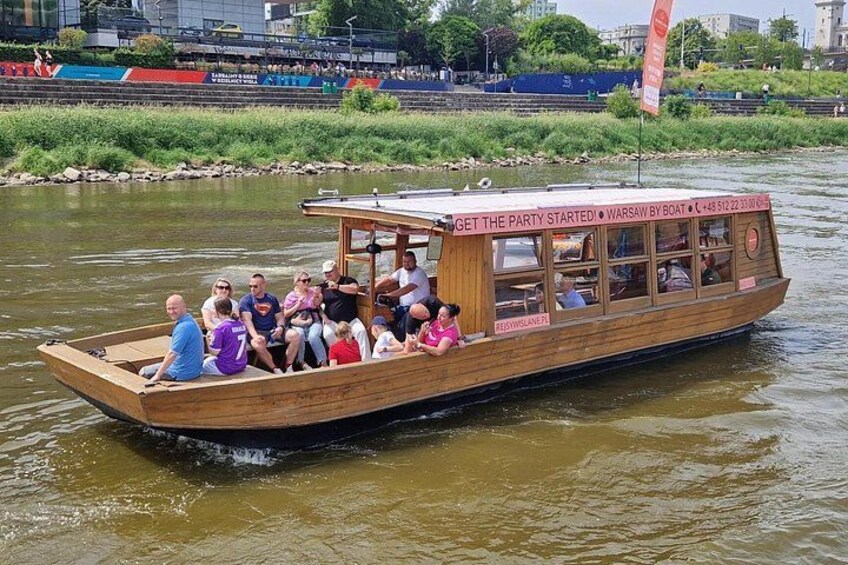 Un bateau en bois, avec des personnes à bord, flottant sur une rivière. 2