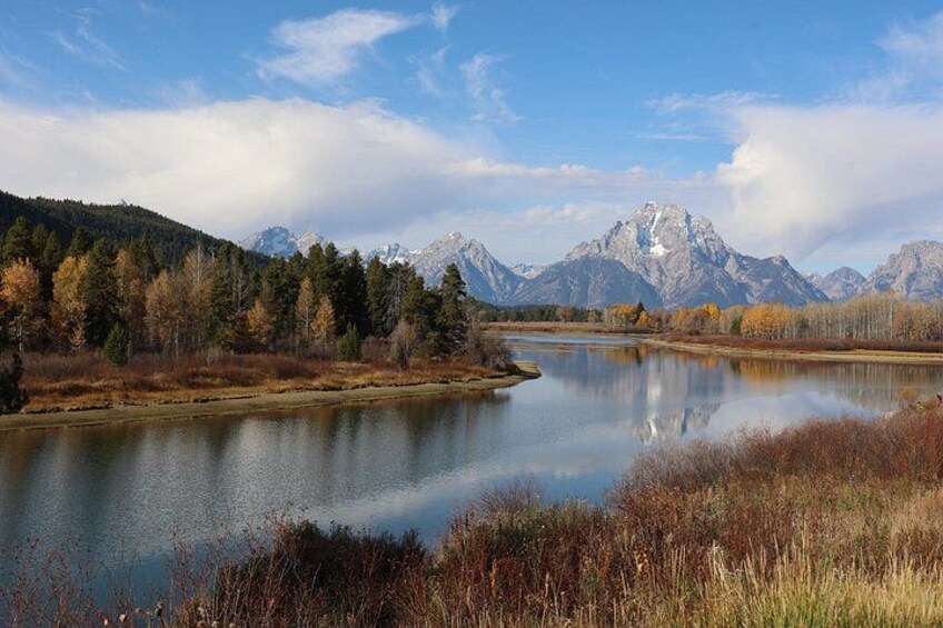 Un lago tranquilo rodeado de árboles otoñales y montañas. 2