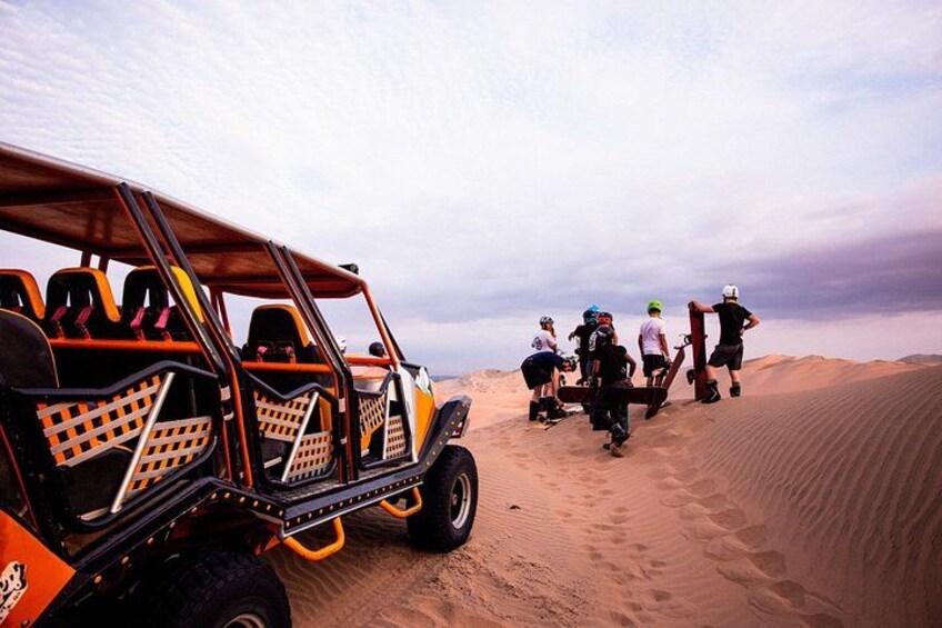 A dune buggy with passengers, a desert landscape, and sand dunes. 2