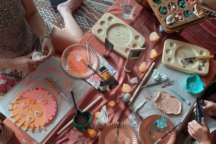 A table with art supplies, including paint, brushes, and palettes. 1