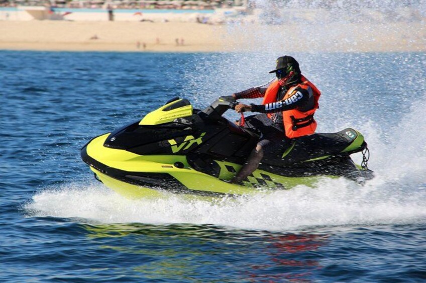 En person kører på en gul og sort jetski på vandet. 1