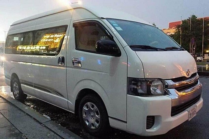 A white van parked on a wet road with reflective windows. 5