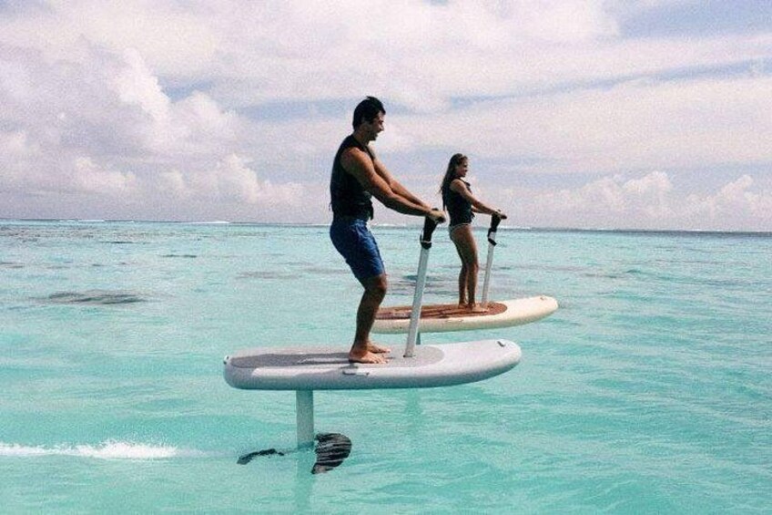 Zwei Personen stehen auf einer schwimmenden Plattform in türkisblauem Wasser. 5