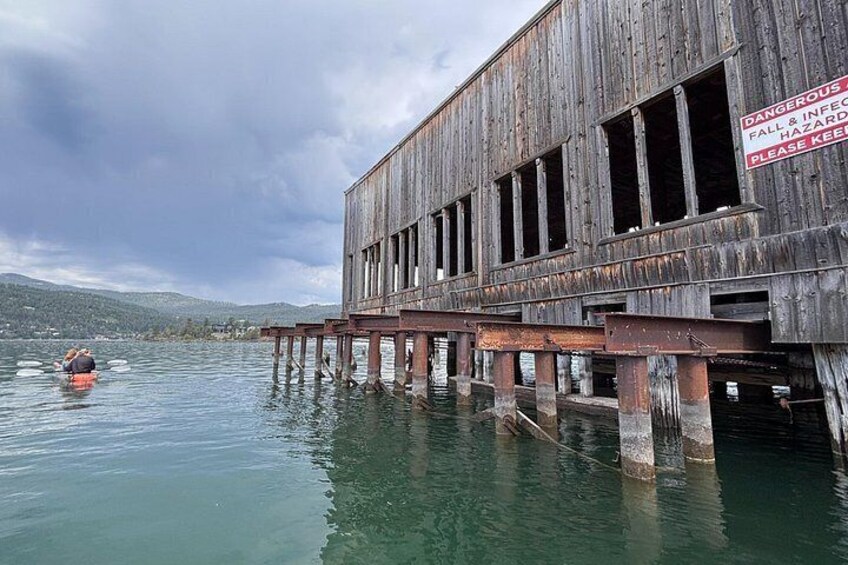 A dilapidated wooden structure extending into a body of water with a warning sign. 4
