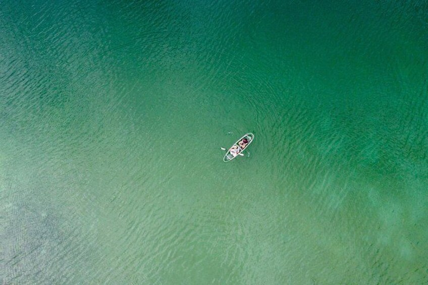 A small boat on a calm, greenish-blue body of water. 4