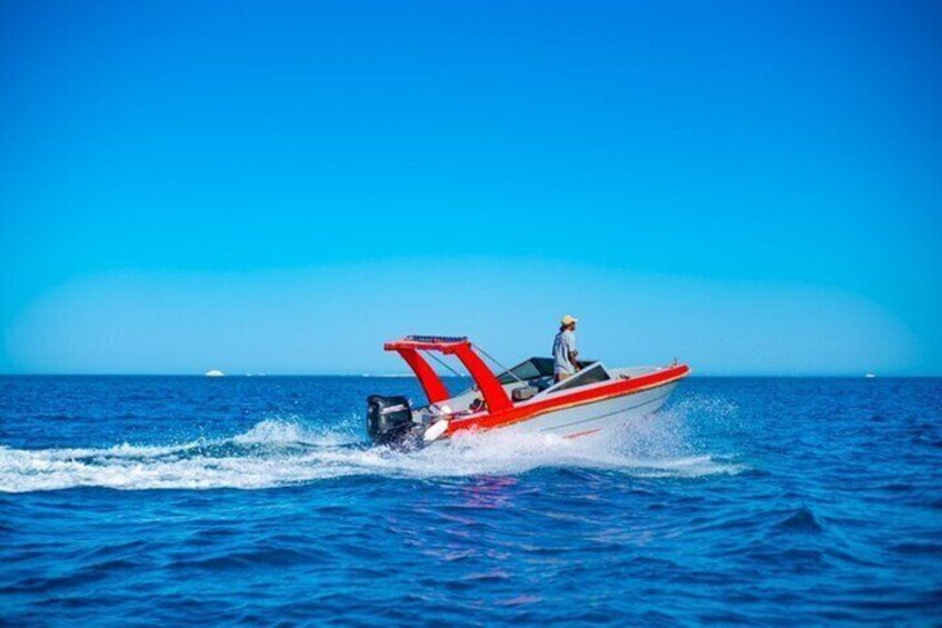 Un motoscafo rosso con un solo passeggero sull'acqua. 2