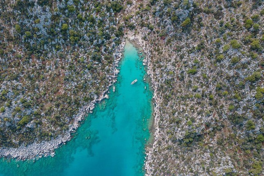Vista aérea de una zona costera turquesa con terreno rocoso y vegetación escasa. 5
