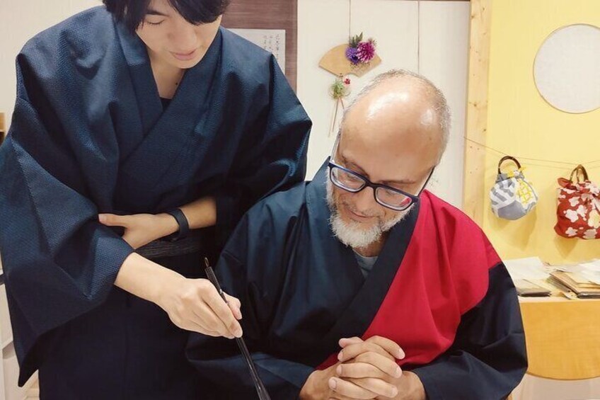 A person in a blue robe assisting another person in a red and black robe. 1