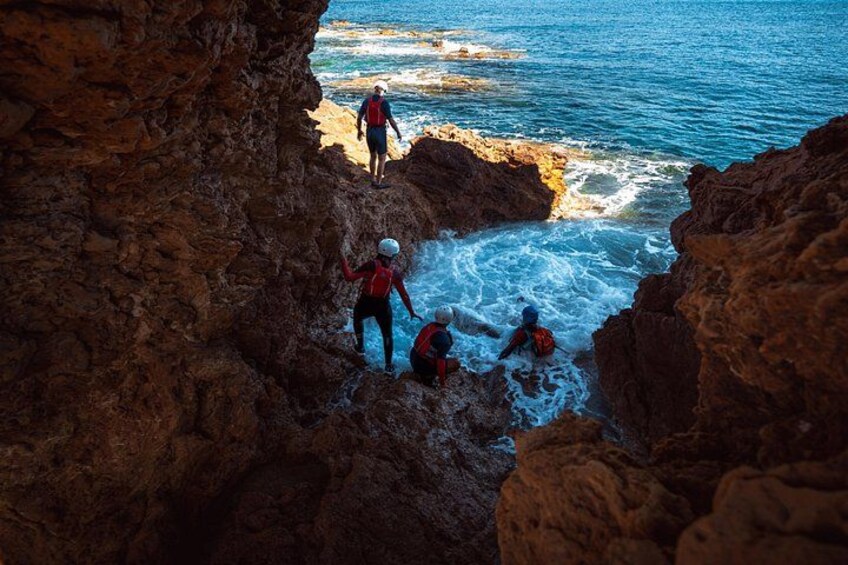People climbing rocky cliffs by the sea. 5