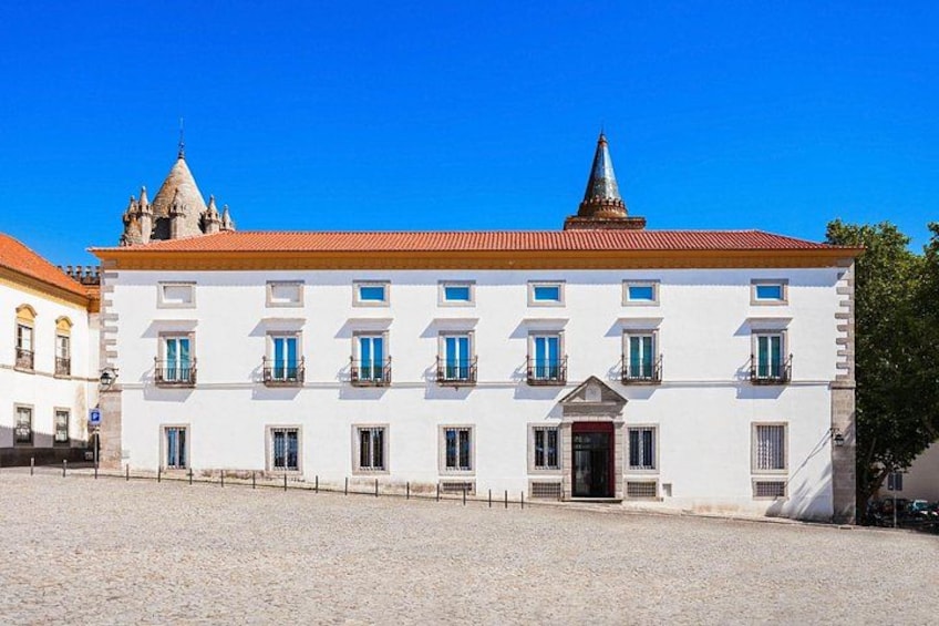 A white building with a red roof and a dome-shaped tower. 3