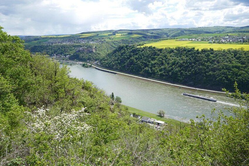 A river winding through a valley with lush greenery and a boat in the water. 2