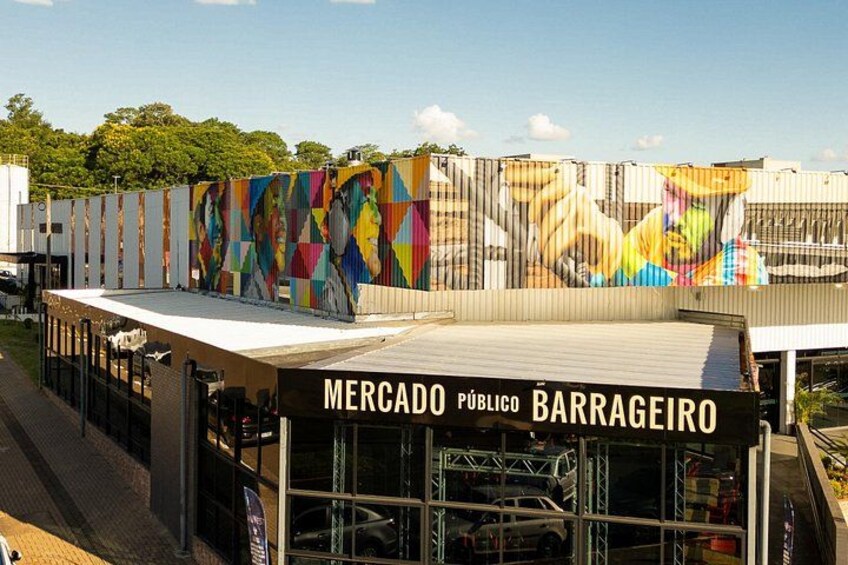 A market named Mercado Público Barrageiro with a colorful mural on the fence. 2