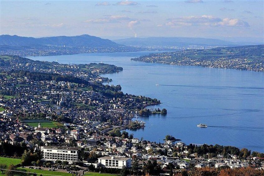 A coastal cityscape with a large body of water, a small island, and distant mountains. 4
