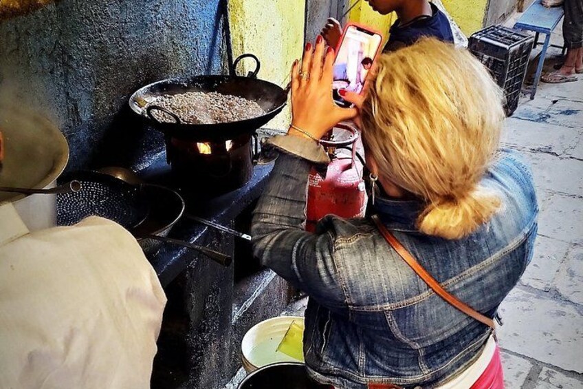 Une personne qui cuisine sur une cuisinière, avec une grande marmite, une poêle et un téléphone intelligent. 2