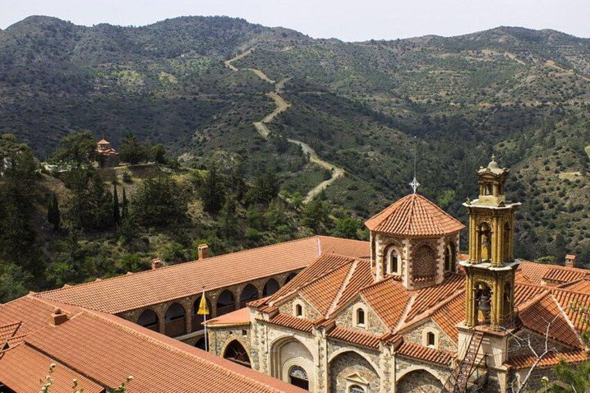A church with a bell tower and arched windows, surrounded by a mountainous landscape. 3