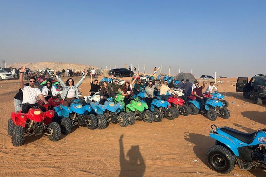 A group of people on quad bikes in a desert setting. 2