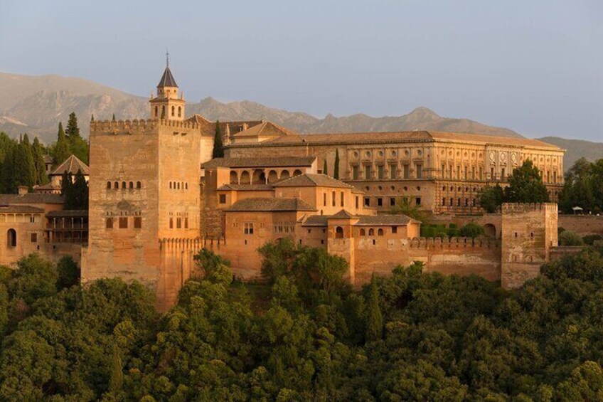 Une forteresse historique, dotée d’une tour imposante, entourée d’une végétation luxuriante et avec des montagnes en toile de fond. 5