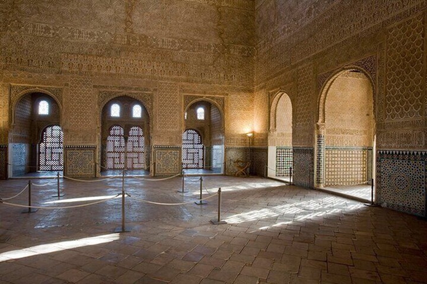Un intérieur caractérisé par des arches, des murs décorés de motifs et un sol carrelé. 3