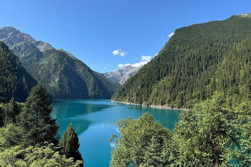 Un lac turquoise, entouré d’une forêt dense et de montagnes. 1