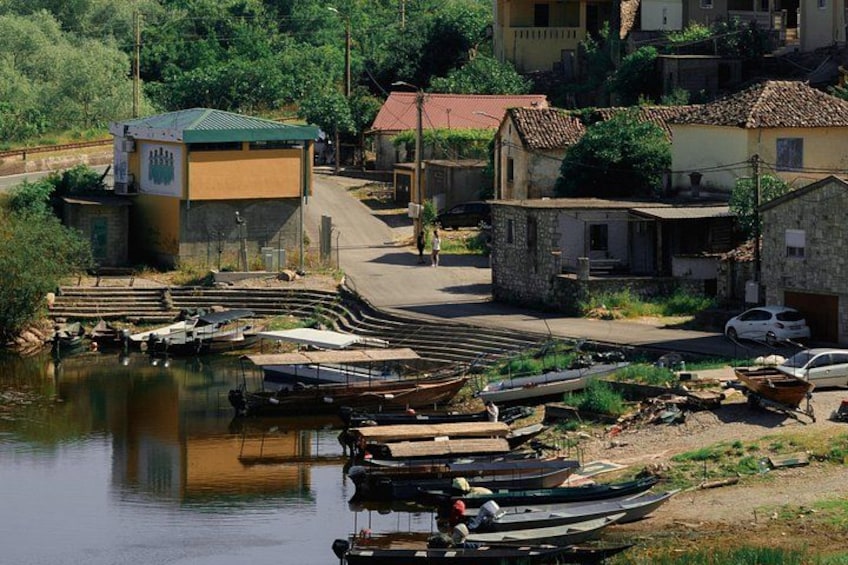 Un borgo lungo il fiume con barche ormeggiate, un piccolo edificio con tetto verde e case tradizionali. 2