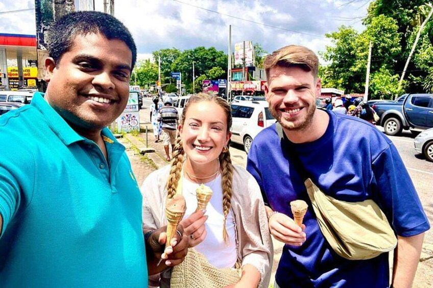 Three people holding ice cream cones in an urban setting with cars and buildings in the background. 5