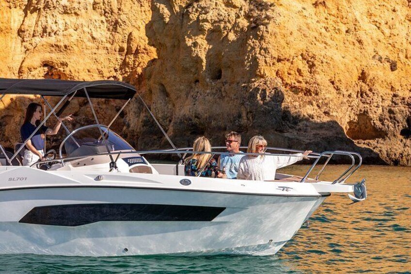 A boat with people on it near a rocky coastline. 3