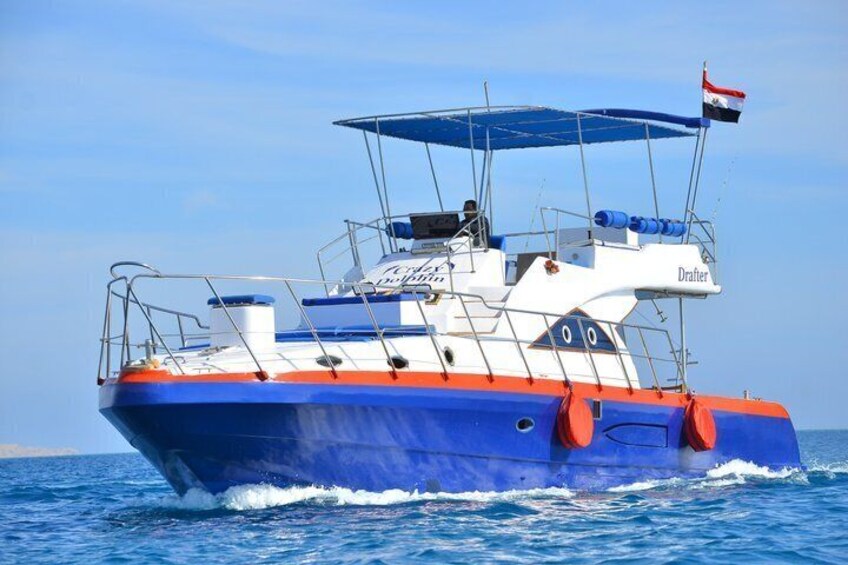 Een blauw en wit boot met een rode streep, genaamd 'Drafter', vaart over het water. 4