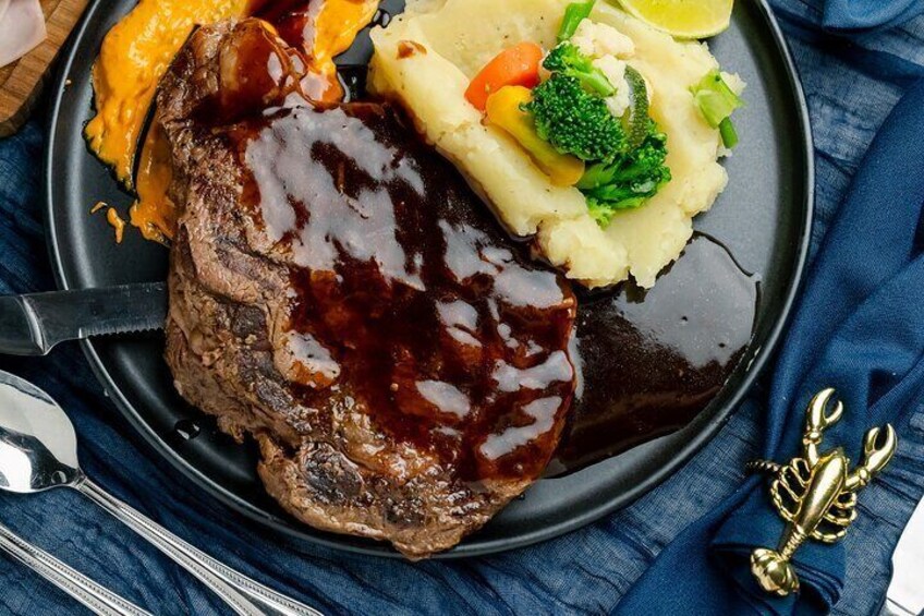 Une assiette contenant un steak, de la purée de pommes de terre et des légumes. 3
