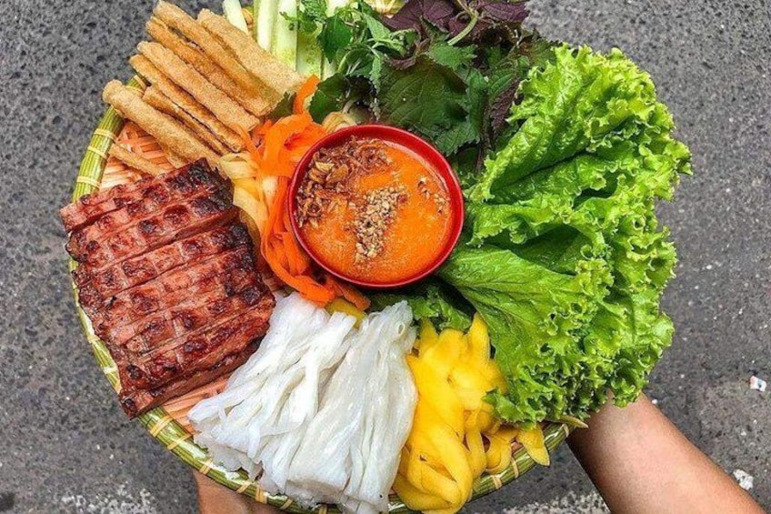 Een bord eten met gegrild vlees, groenten en een schaaltje saus. 4