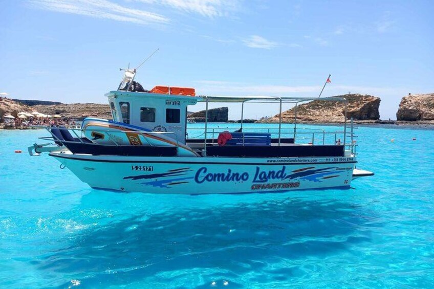 Un bateau nommé « Comino Land », avec une côte rocheuse en arrière-plan. 2