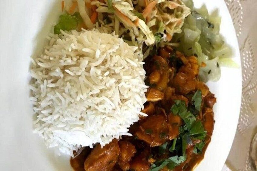 A plate of food with white rice, a curry dish, and a side salad. 3
