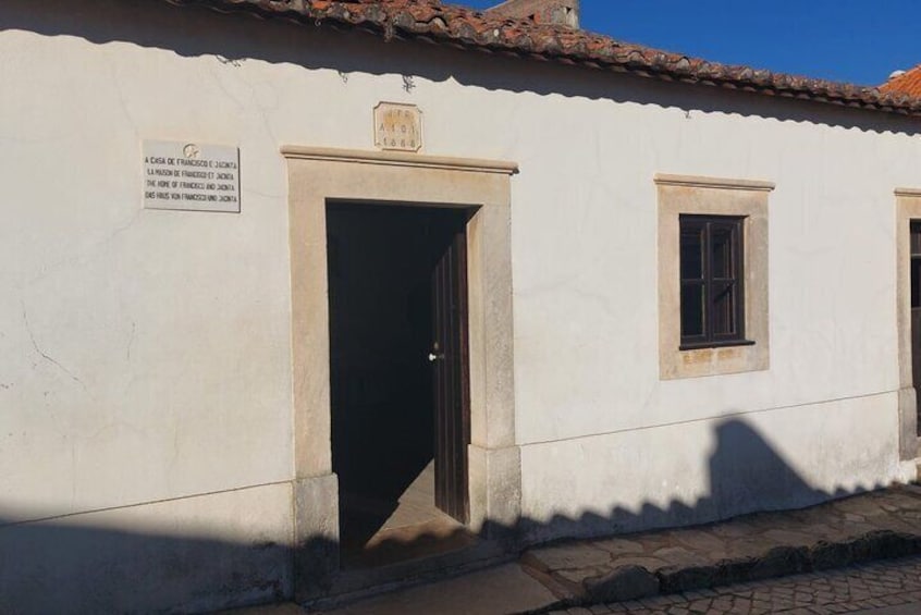 A building with a sign, a door, and two windows. 1