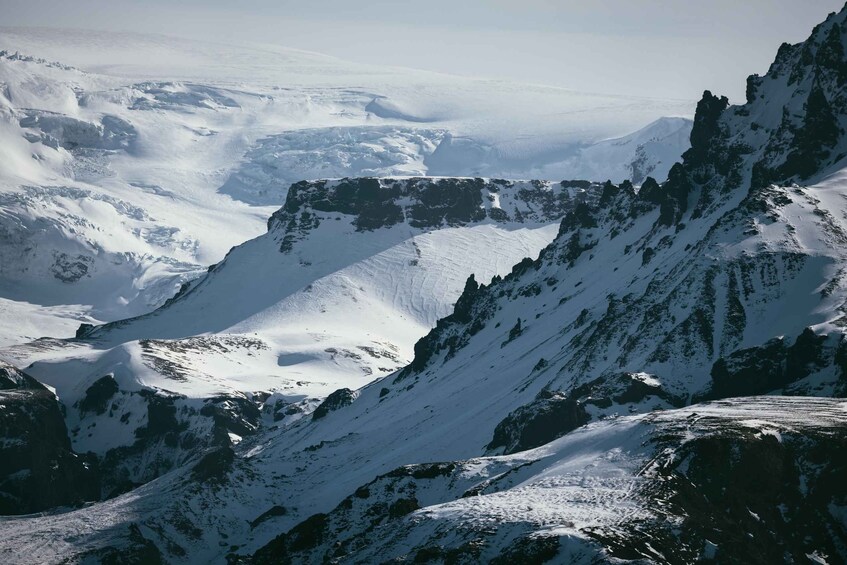 A snow-covered mountain range with sharp peaks and deep valleys. 3