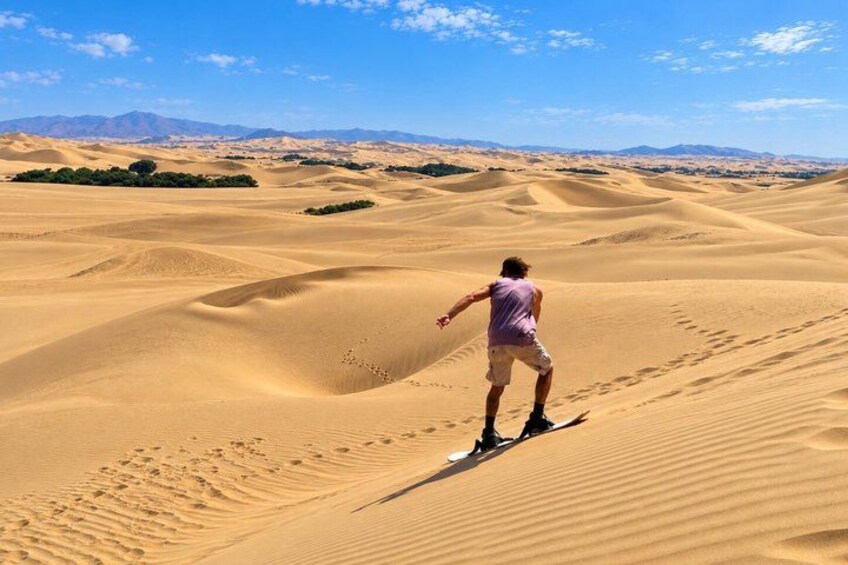 A person riding a dune buggy on a sandy dune. 3