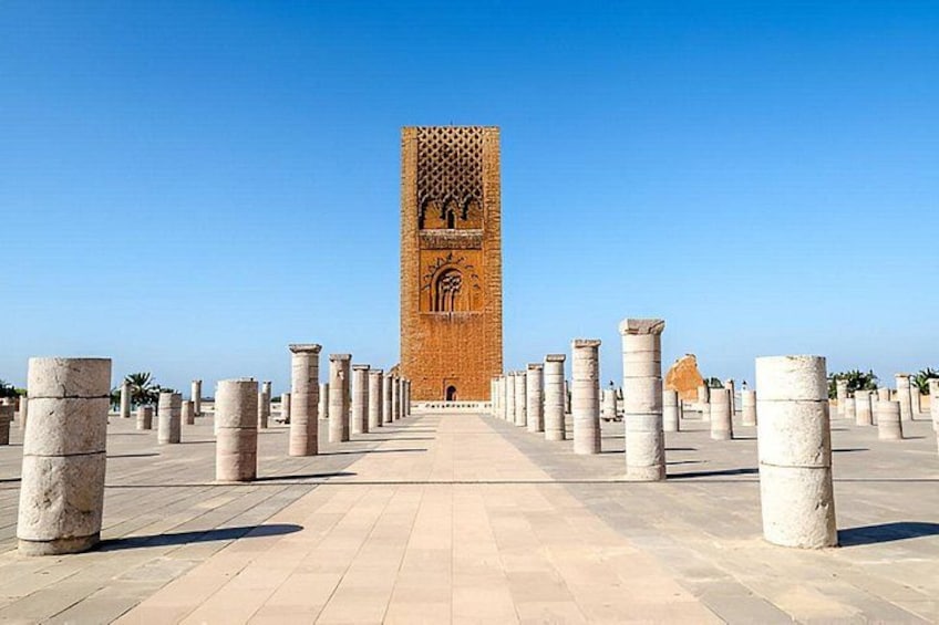 A historical tower with intricate carvings, surrounded by evenly spaced columns. 4