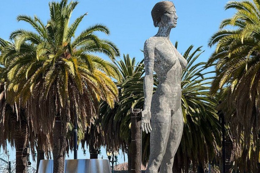 Une statue représentant une figure humaine tenant une épée, entourée de palmiers. 4