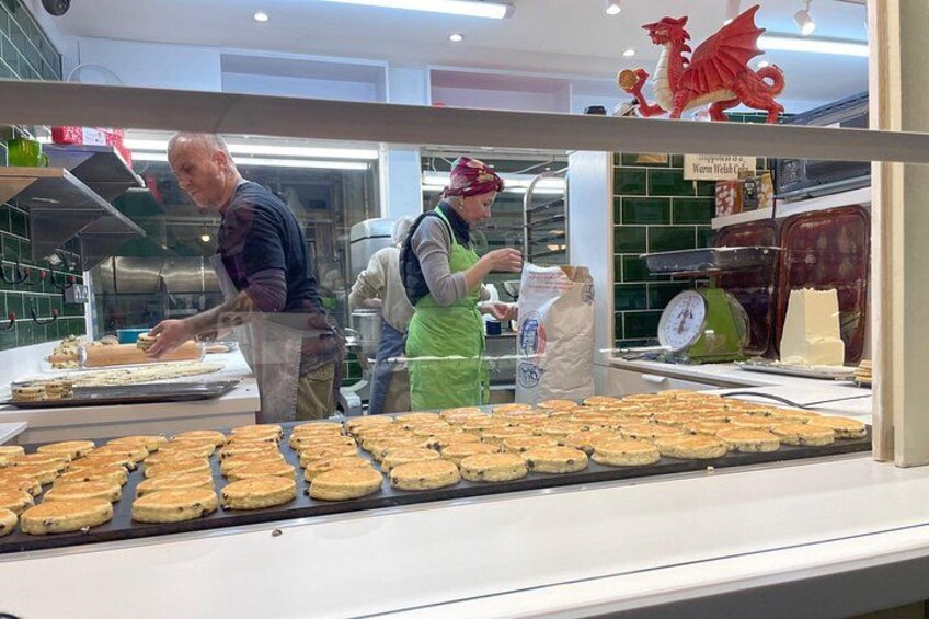 Una panadería con pasteles exhibidos en el escaparate y una decoración de dragón en la parte superior. 3