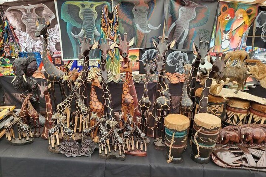 Una varietà di figurine artigianali di animali e tamburi esposti su un tavolo. 2