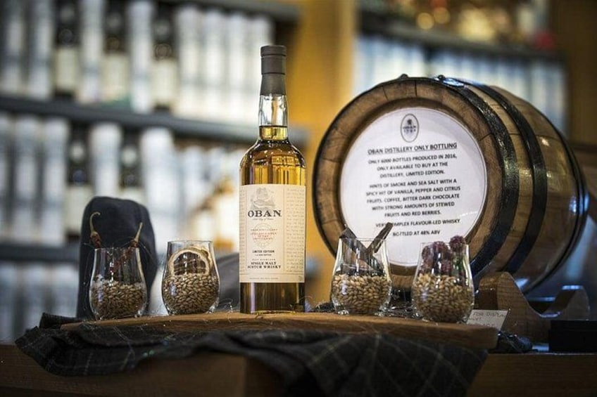 A bottle of OBN whiskey, a wooden barrel, and glasses on a table. 1