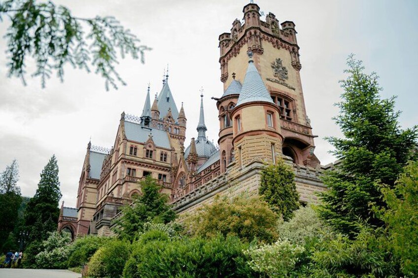 A historic castle with multiple towers and turrets, surrounded by lush greenery. 3