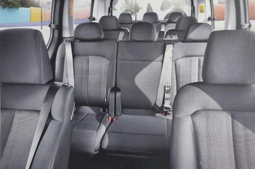 A vehicle interior with grey seats and seat belts. 2
