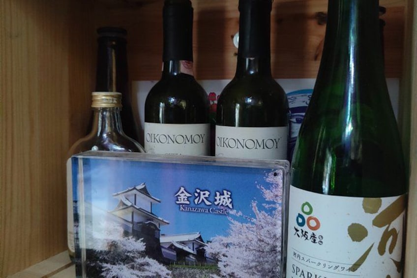 Three bottles of wine and a book with Japanese text and a castle illustration. 2