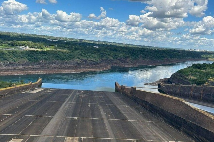 A dam with a river, a bridge, and a hilly landscape. 2