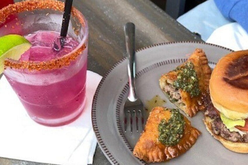 Un plato con comida: una hamburguesa, dos pasteles y una bebida rosada. 3