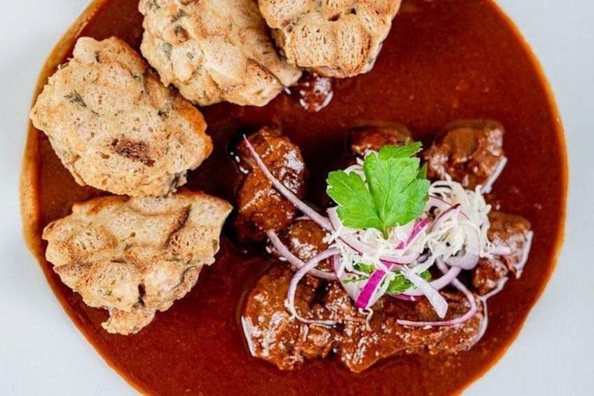 A dish with meat, sauce, and bread. 2