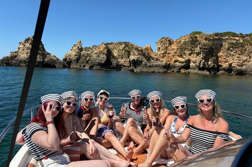 A group of people on a boat with rocky cliffs in the background. 5